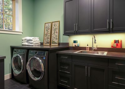 Sleek black laundry room cabinets