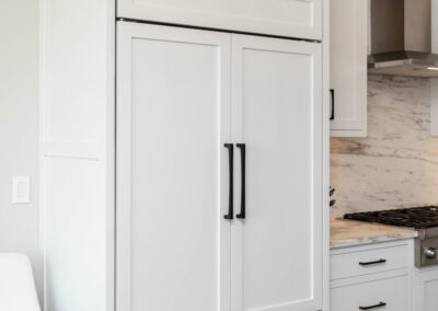 Sleek white custom kitchen cabinetry with black hardware